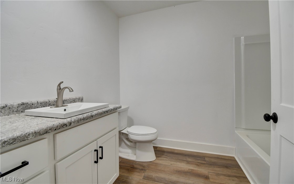 10337 Ragersville Road Southwest Baltic, OH 43804 - Photo 14 of 35 Bathroom with hardwood / wood-style floors, vanity, and toilet
