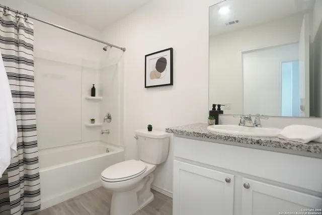 a bathroom with a granite countertop toilet sink and bathtub