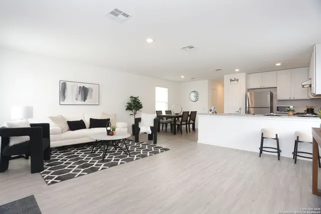 a living room with furniture and kitchen view