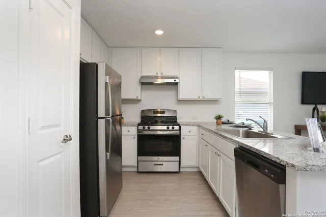 a kitchen with a sink appliances and cabinets