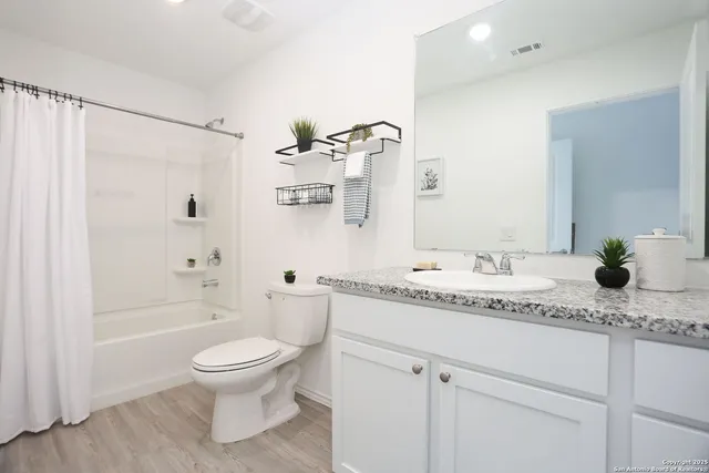 a bathroom with a granite countertop sink toilet and shower