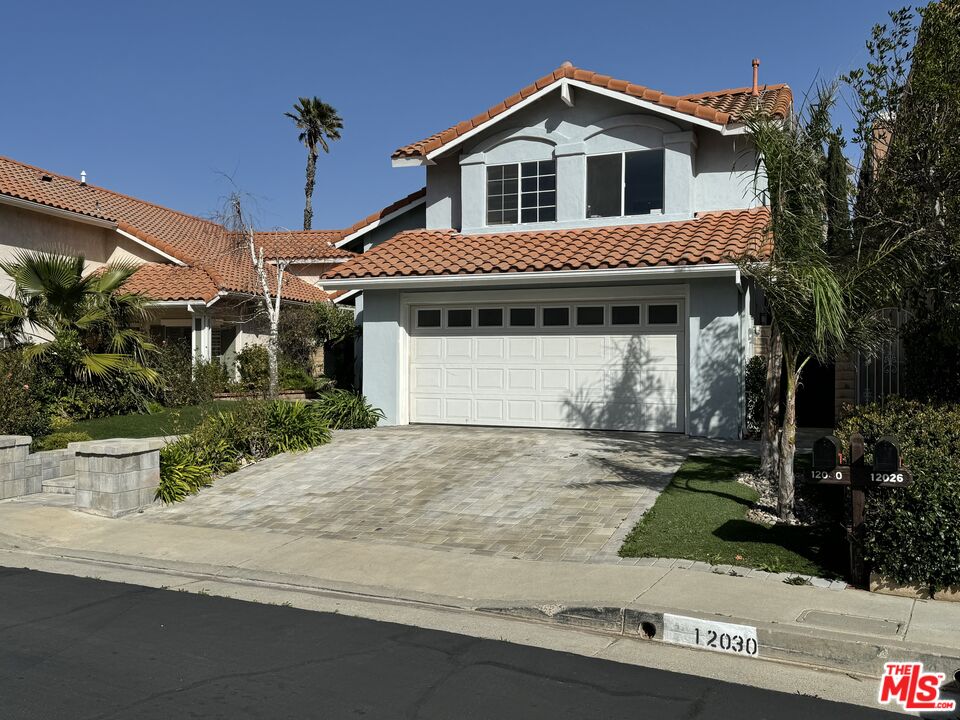 12030 Falcon Crest Way Porter Ranch, CA 91326 - Photo 1 of 33 a front view of a house with a yard and garage