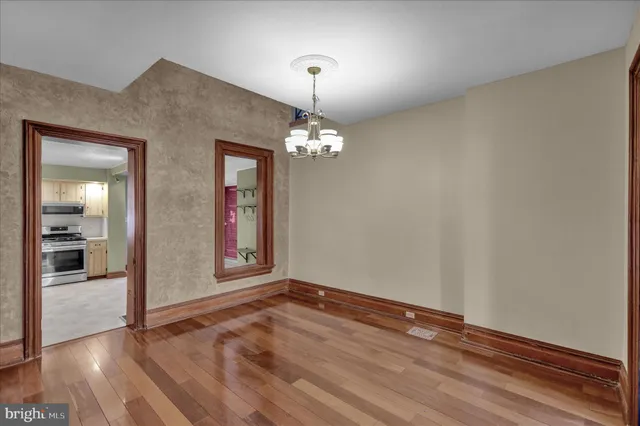 a view of a hallway with wooden floor and front door