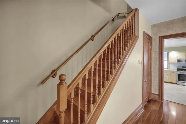 a view of a hallway with wooden floor and a living room