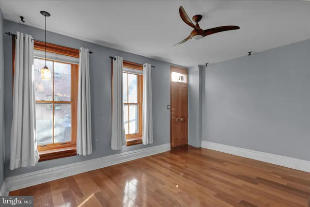 a view of a hallway with entryway wooden floor and front door