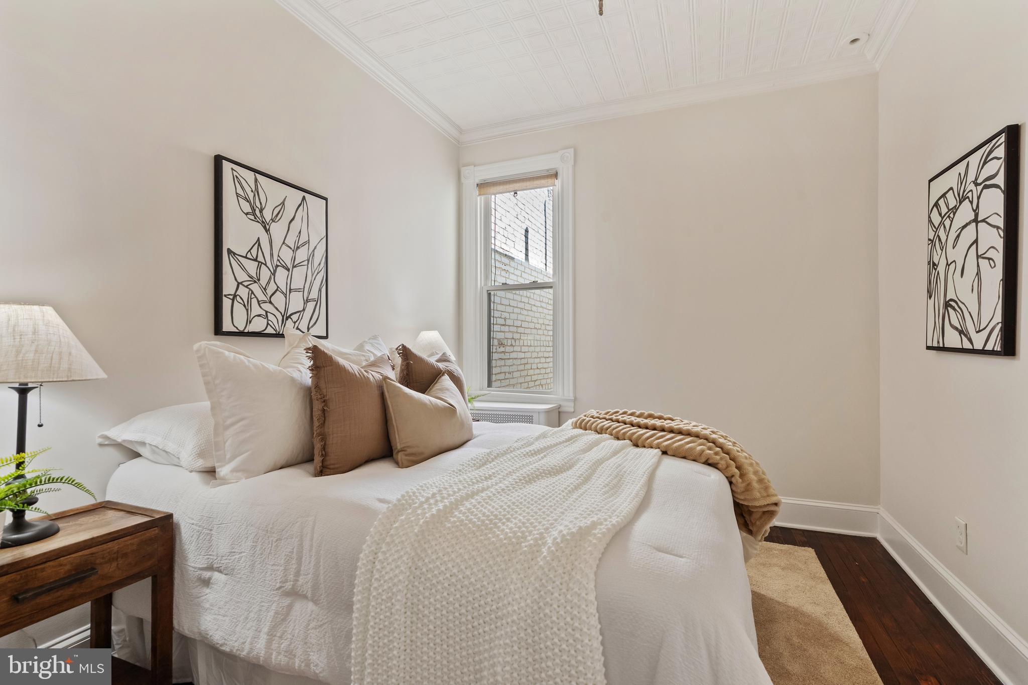 705 7th Street Northeast Washington, DC 20002 - Photo 28 of 48 a bedroom with a bed and a lamp on dresser