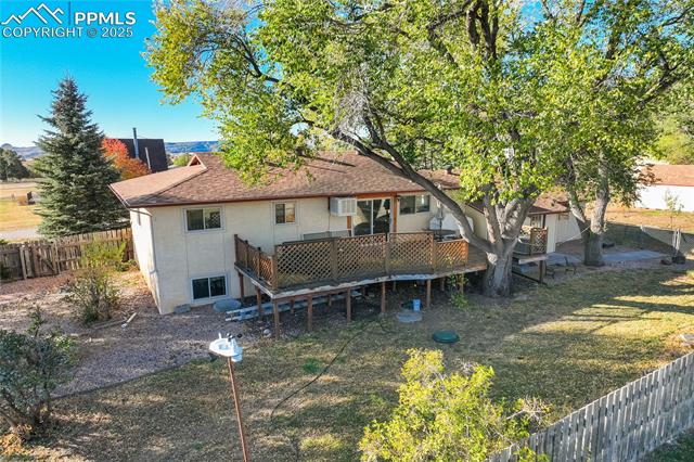 8340 Piute Road Colorado Springs, CO 80926 - Photo 46 of 48 Back of house featuring a fenced backyard, a deck, stucco siding, and roof with shingles