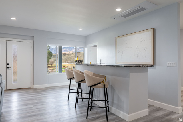 476 Spring Drive Toquerville, UT 84774 - Photo 23 of 95 Kitchen with light wood-style floors, a kitchen bar, dark stone counters, recessed lighting, and a mountain view