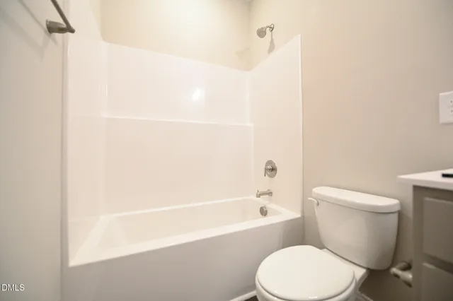 a white toilet sitting next to a bath tub