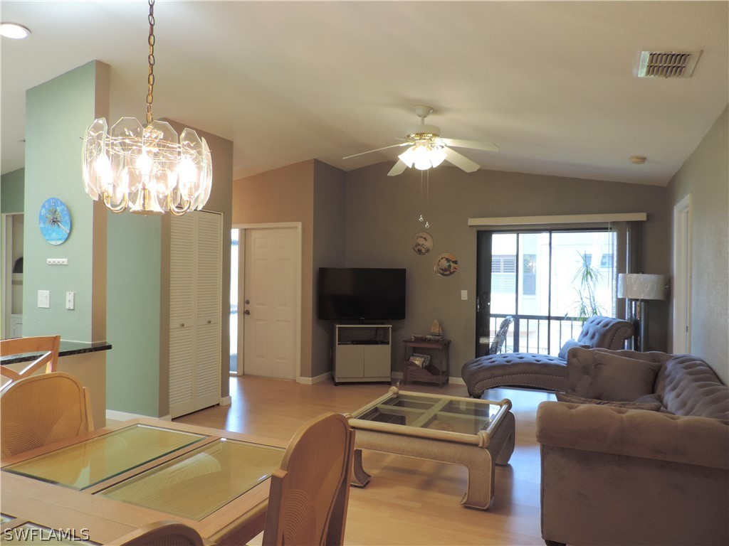 17624 Village Inlet Court Fort Myers, FL 33908 - Photo 6 of 17 a living room with furniture a chandelier and a flat screen tv