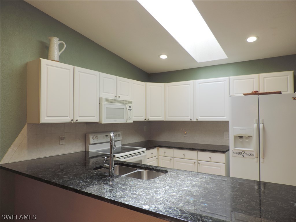 17624 Village Inlet Court Fort Myers, FL 33908 - Photo 8 of 17 a kitchen with kitchen island granite countertop a sink a stove and a refrigerator
