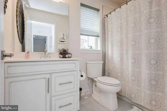 a bathroom with a sink a toilet a mirror and shower curtain