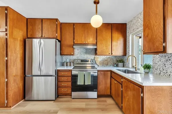 a kitchen with stainless steel appliances granite countertop a refrigerator a sink dishwasher a stove with wooden floor