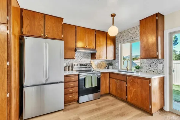 a kitchen with appliances a sink and a refrigerator