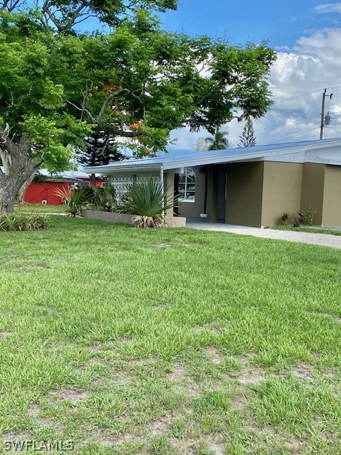 306 Oregon Road West Lehigh Acres, FL 33936 - Photo 21 of 26 a front view of a house with a garden