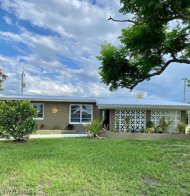306 Oregon Road West Lehigh Acres, FL 33936 - Photo 3 of 26 a front view of a house with a garden