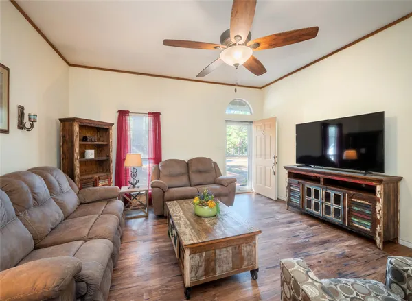 a living room with furniture a fireplace and a ceiling fan