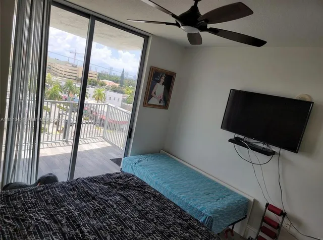 a living room with a flat screen tv and a floor to ceiling window