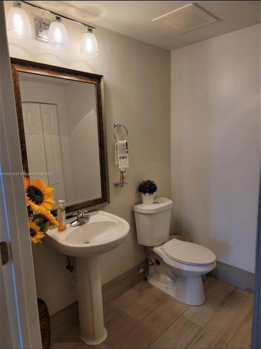 140 South Dixie Highway, Unit 519 Hollywood, FL 33020 - Photo 7 of 28 a bathroom with a toilet sink and mirror