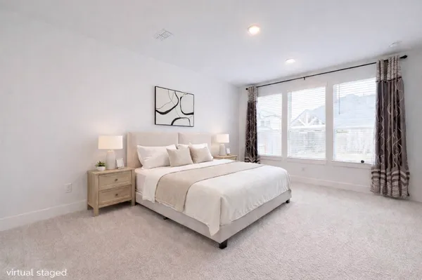 a bedroom with a bed and a large window