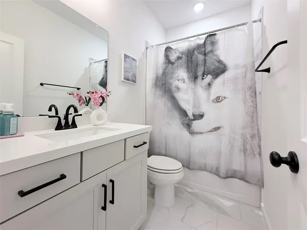 a bathroom with a sink toilet and shower