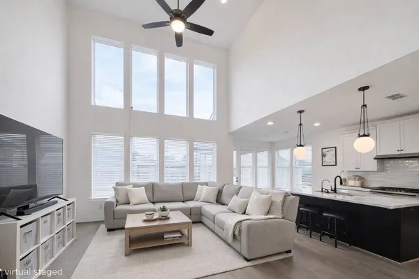 a living room with furniture ceiling fan and a flat screen tv