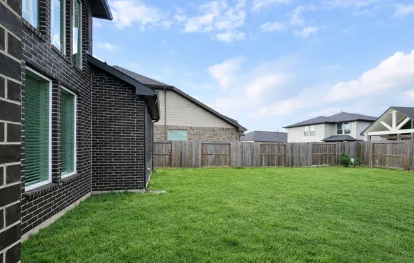 a view of a small yard in front of a house with wooden fence