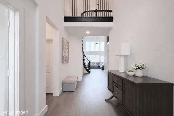 a hallway with wooden floor windows and stairs