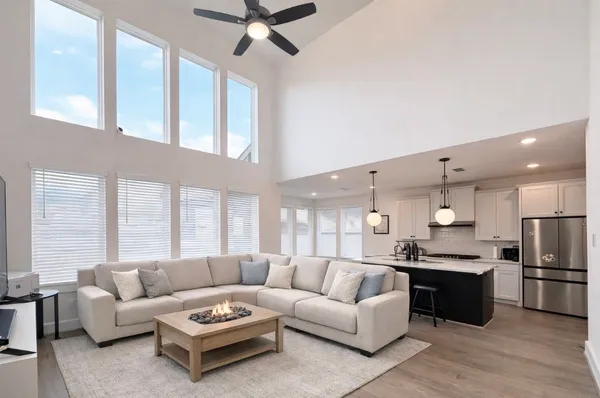 a living room with furniture kitchen and a large window
