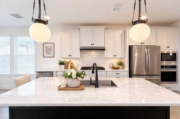a kitchen with kitchen island granite countertop a table and chairs in it