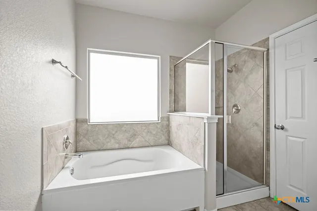 a bathroom with a tub shower and a sink