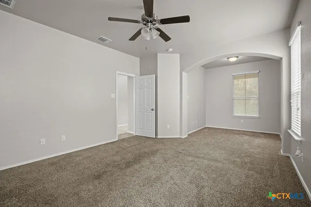 an empty room with fan and windows