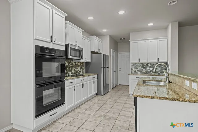 a kitchen with stainless steel appliances a stove sink and microwave