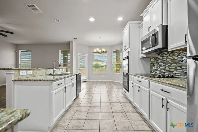 a large kitchen with stainless steel appliances lots of counter space and wooden floor