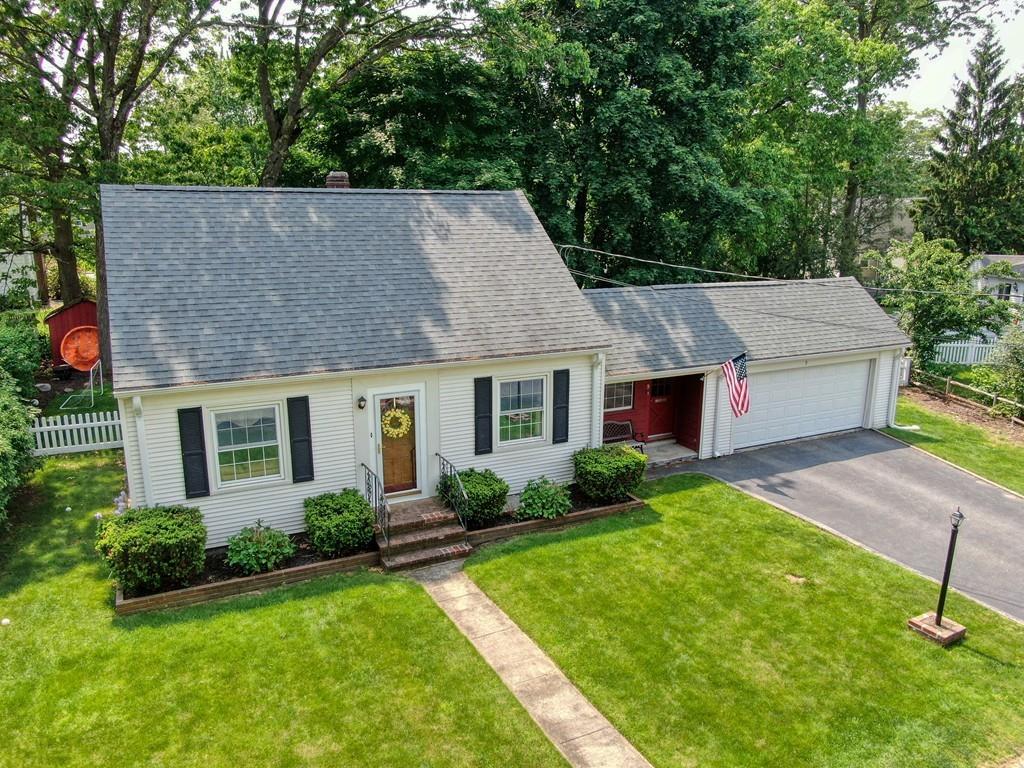 a aerial view of a house next to a yard with potted plants and large trees