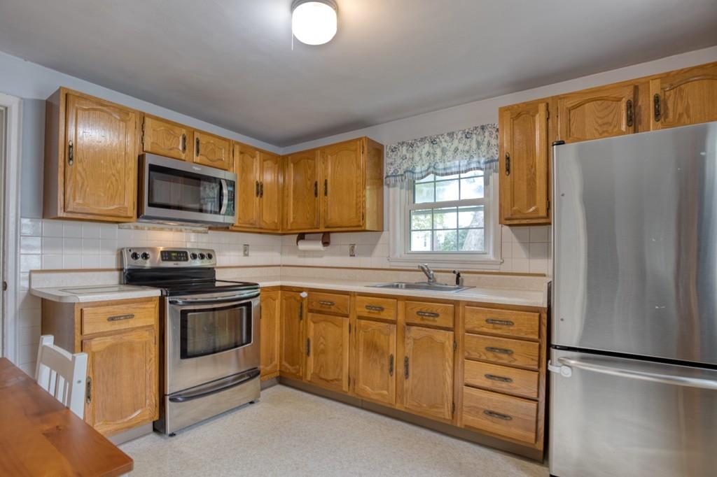 9 Laurel Road Braintree, MA 02184 - Photo 3 of 16 a kitchen with stainless steel appliances granite countertop a stove a sink and a microwave