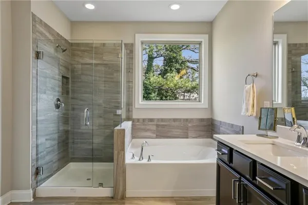 a bathroom with a bath tub a sink and a shower