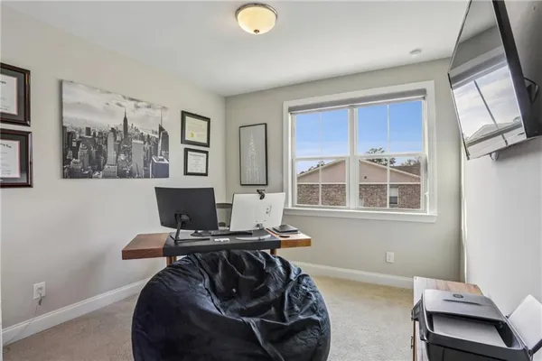 a view of a workspace with furniture and a window