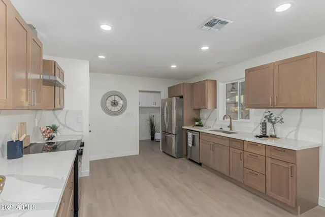 a kitchen with stainless steel appliances granite countertop a sink stove and refrigerator