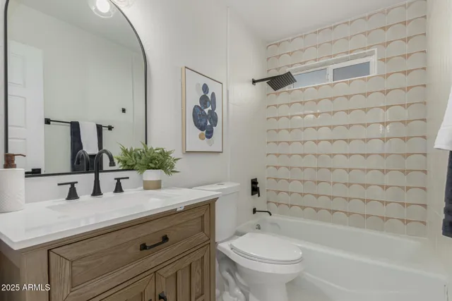 a bathroom with a granite countertop sink a toilet and a bathtub