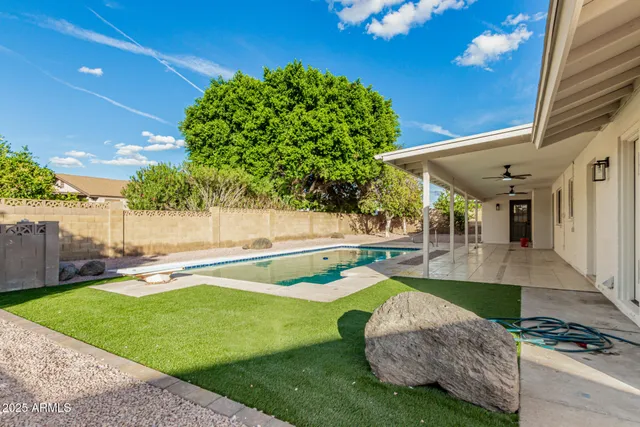 a swimming pool with outdoor seating and yard