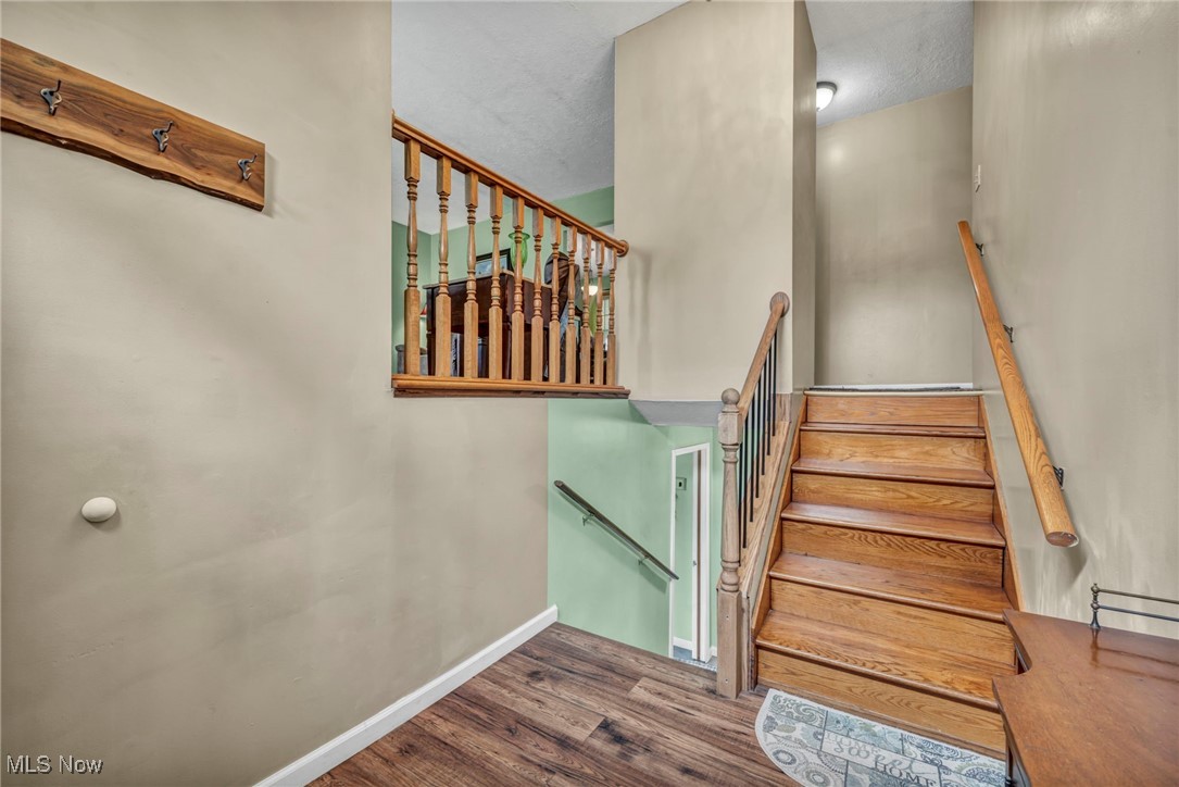 Stairs with wood finished floors and baseboards