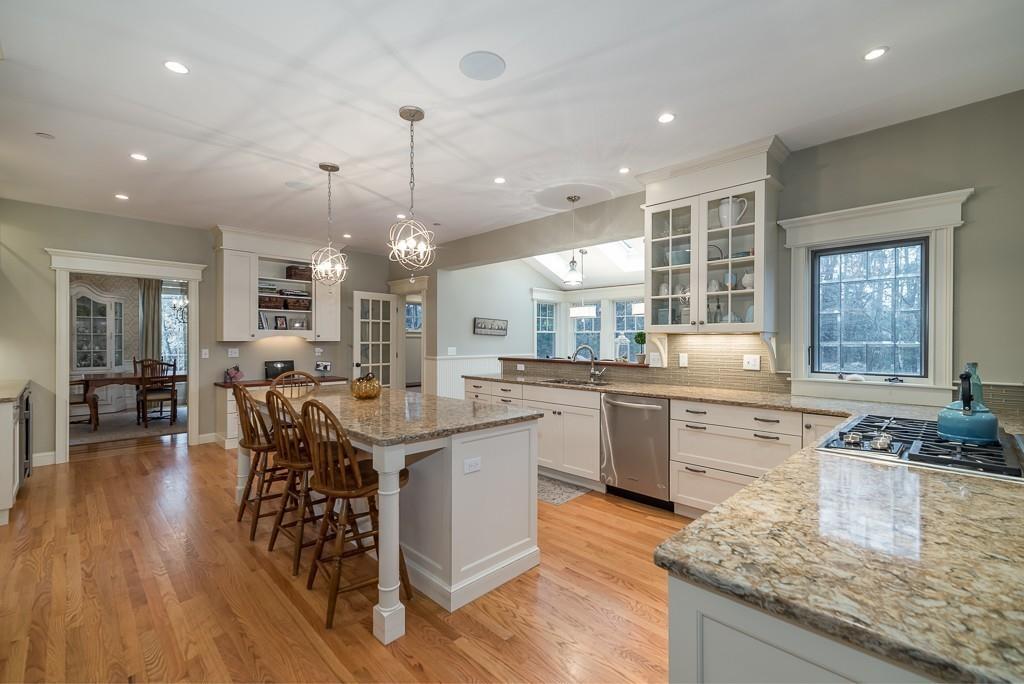 32 Parsons Hill Road Wenham, MA 01984 - Photo 5 of 29 a kitchen with stainless steel appliances granite countertop a stove top oven a sink dishwasher a dining table and chairs with wooden floor