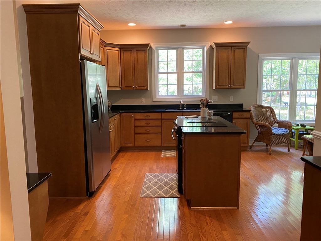 Kitchen has beautiful cabinetry, hardwood floors,