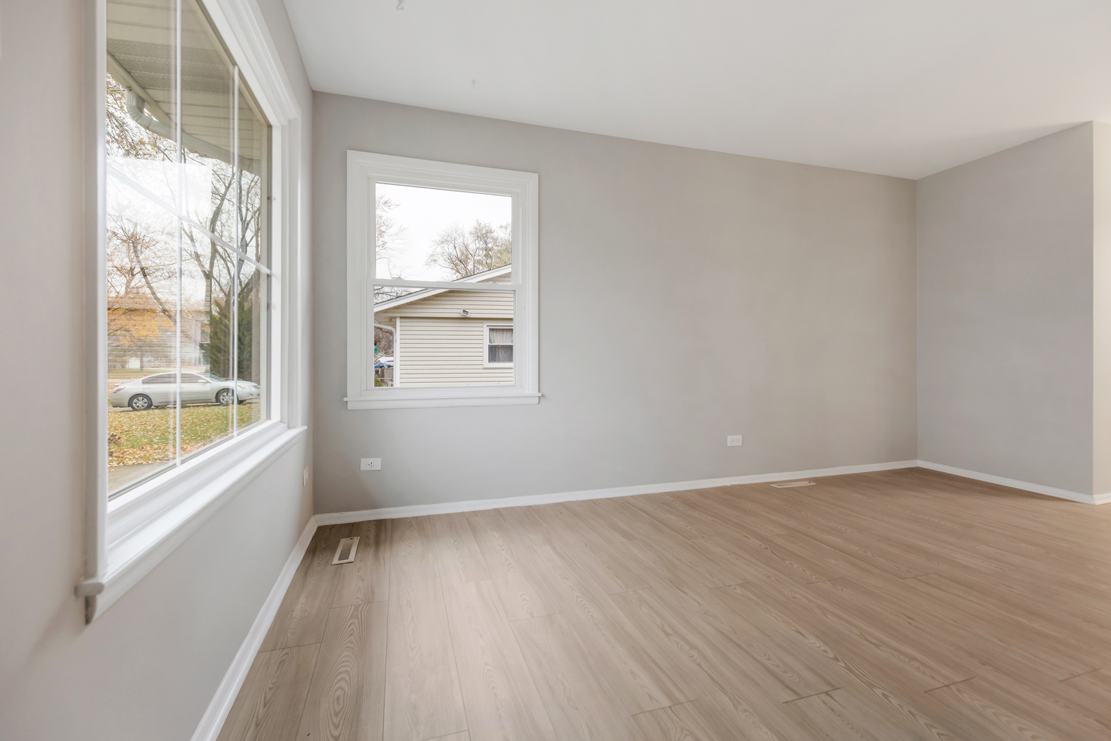6971 Hanover Street Hanover Park, IL 60133 - Photo 3 of 20 an empty room with wooden floor and windows