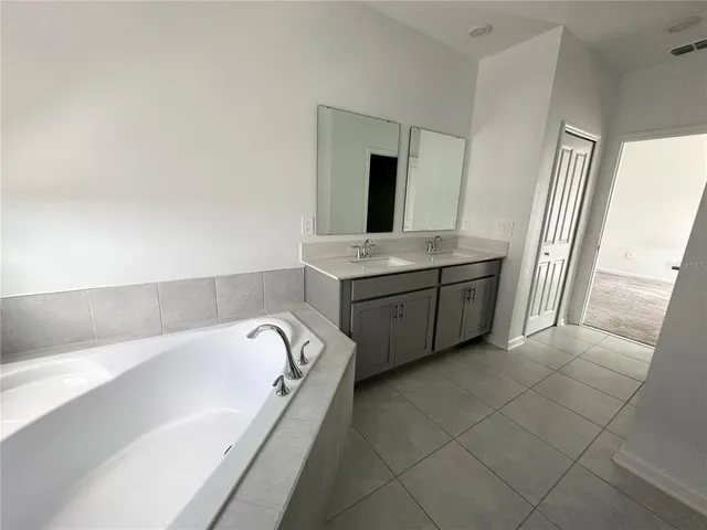 a bathroom with a tub sink and mirror