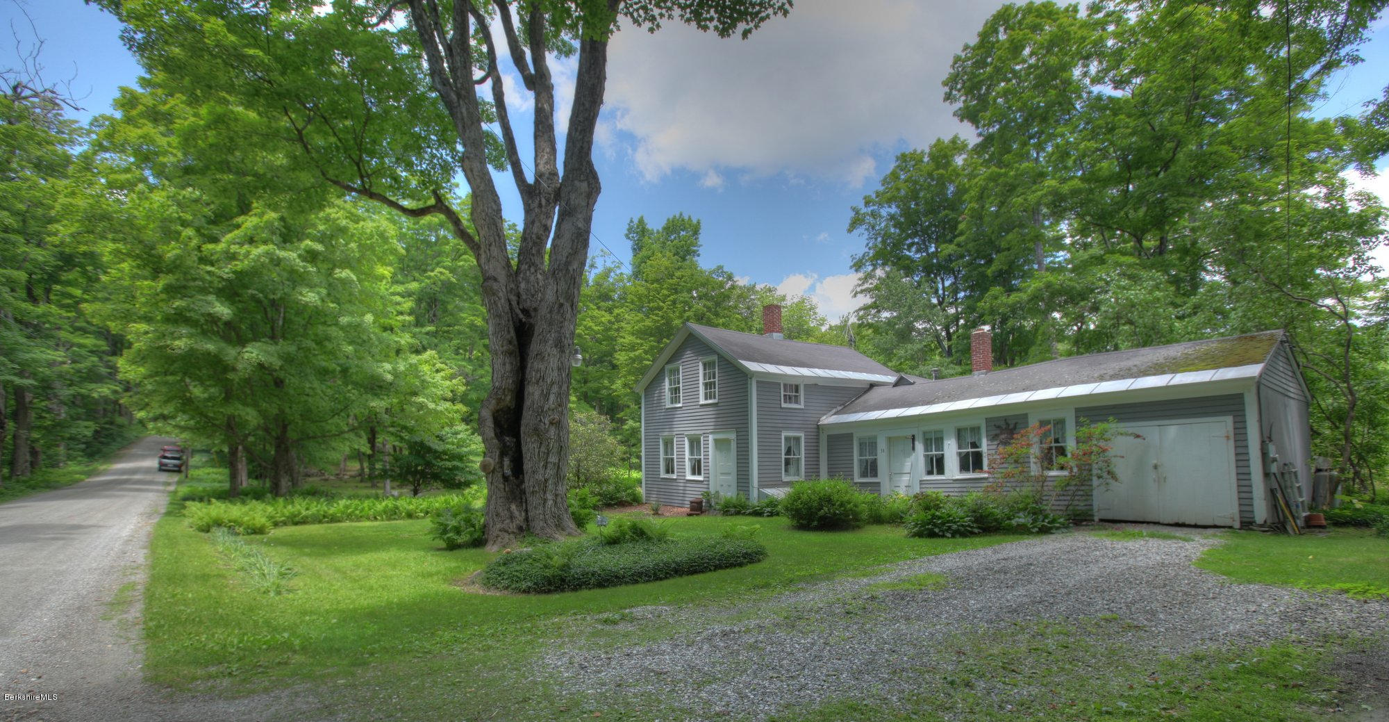 58 Mt Hunger Road Monterey, MA 01245 - Photo 2 of 32 a view of a brick house next to a yard with big trees