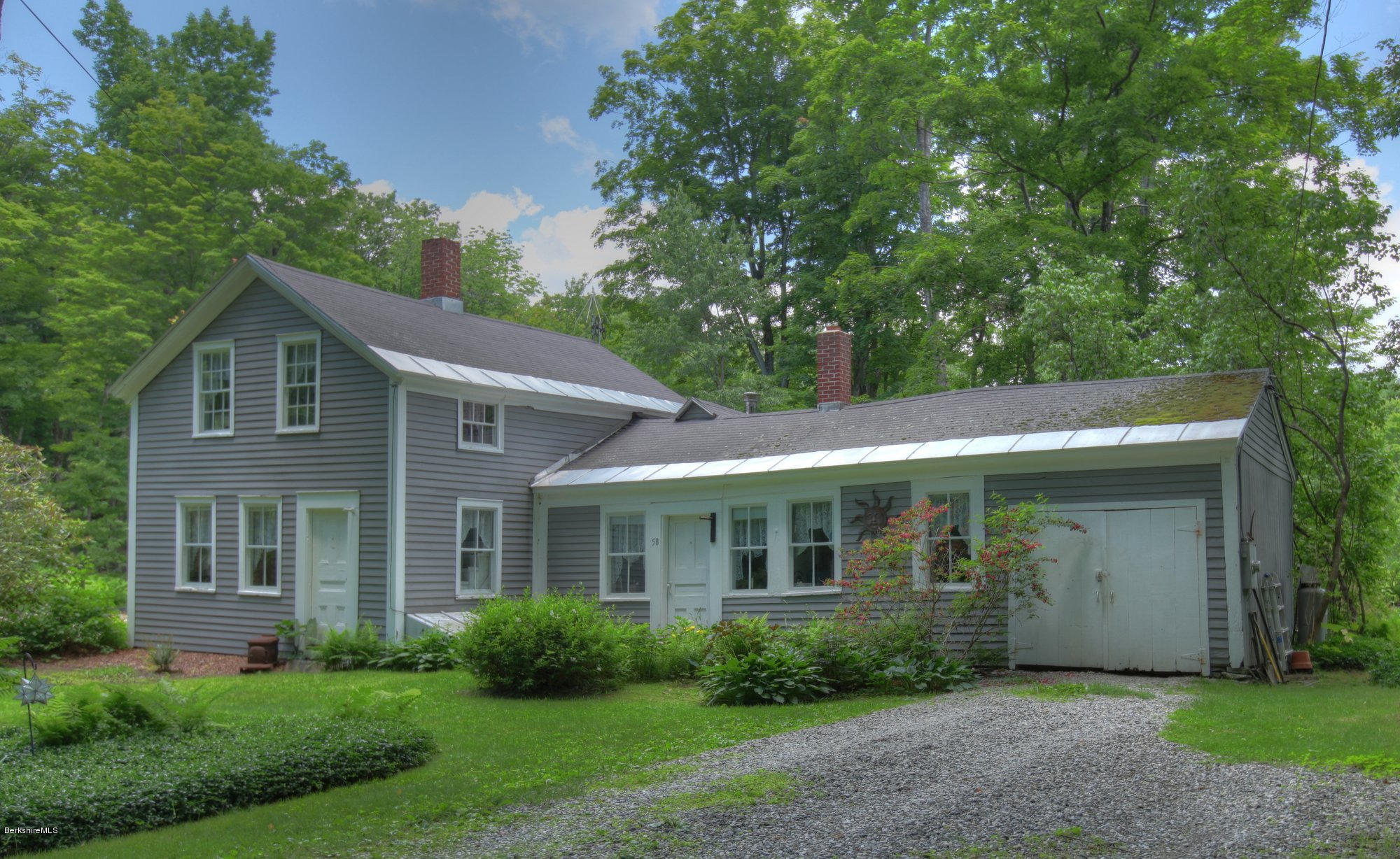 58 Mt Hunger Road Monterey, MA 01245 - Photo 32 of 32 a view of a house with brick walls and a yard with plants and large trees