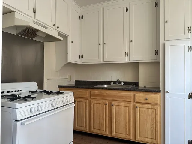 a kitchen with granite countertop cabinets and white appliances