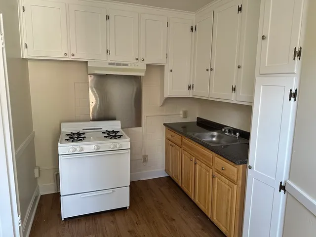 a kitchen with white cabinets and white appliances